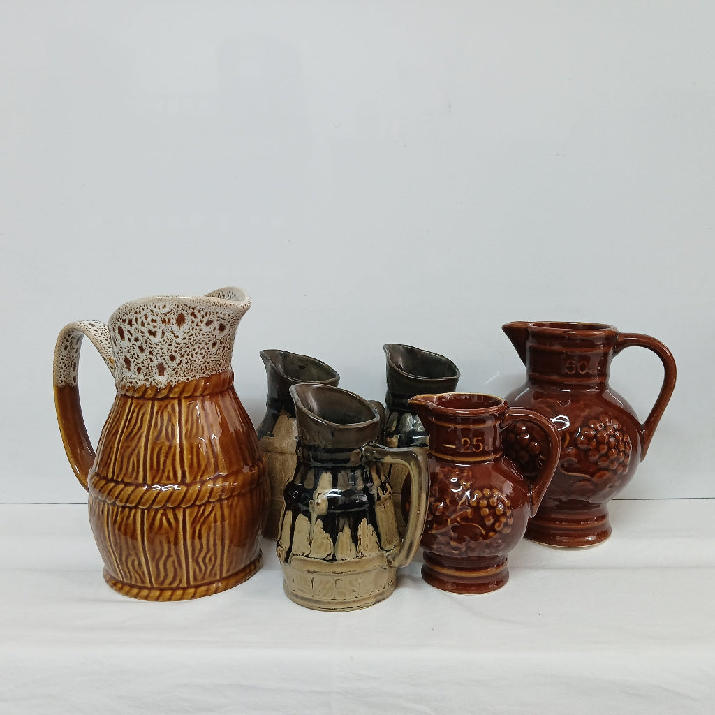 A collection of various brown ceramic vintage wine pitchers at French Originals antiques