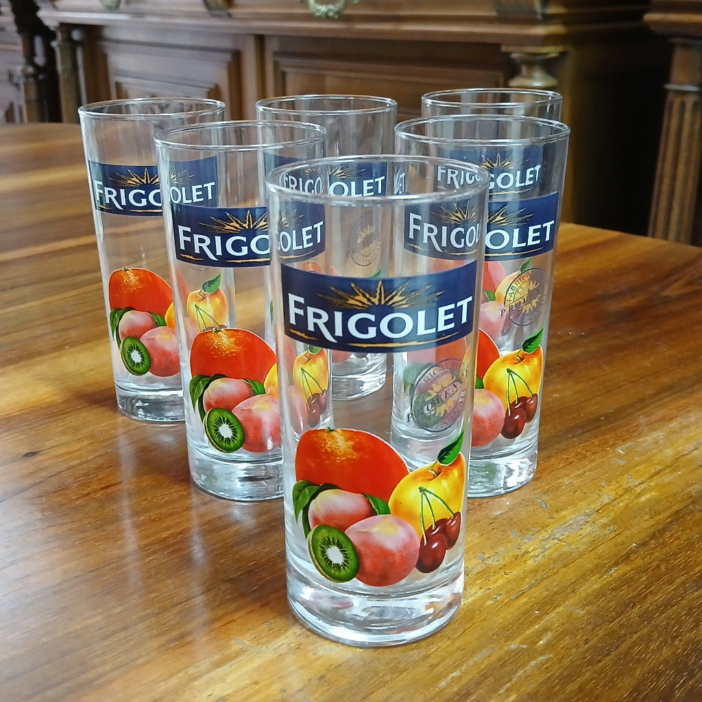 Six Frigolet glasses with fruit decals on a wood table at French Originals antiques
